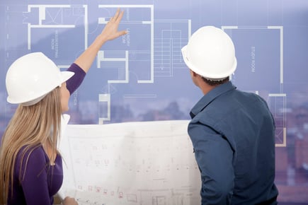 Architects at a construction site looking at the blueprints