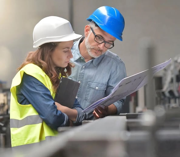 Two construction professionals reviewing drawings on site