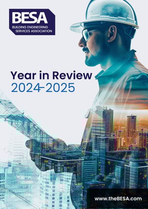 Front cover of the BESA Year in Review 2024–2025, featuring a construction professional overlaid with a city skyline and digital plans, symbolising the future of UK building services.