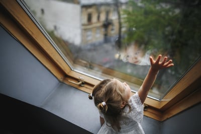 little-girl-is-looking-out-window
