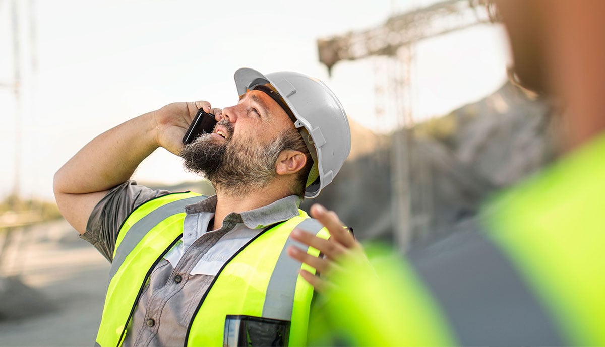quarry-worker-on-site-talking-on-the-phone-2023-03-30-18-31-21-utc-white-hard-hat