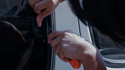Thief breaking into a work van, representing the growing issue of tool theft targeting UK tradespeople.