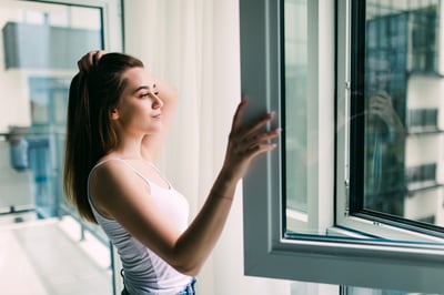 young-woman-opens-plastic-window-fresh-air-smiling-home
