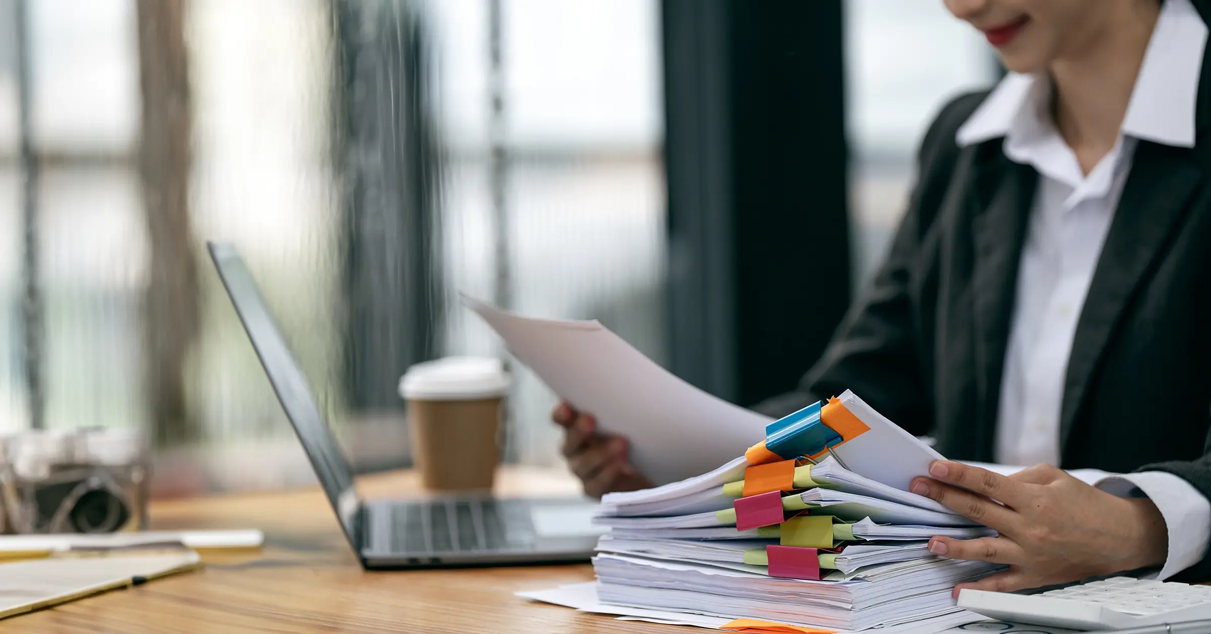 Office Manager Reviewing Employment Law And Compliance Documents At Desk